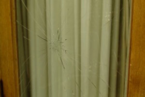 Broken glass panel within timber door.
